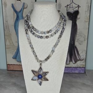 Dendritic agate beads with a starburst and a silver pendant. 22" Drop